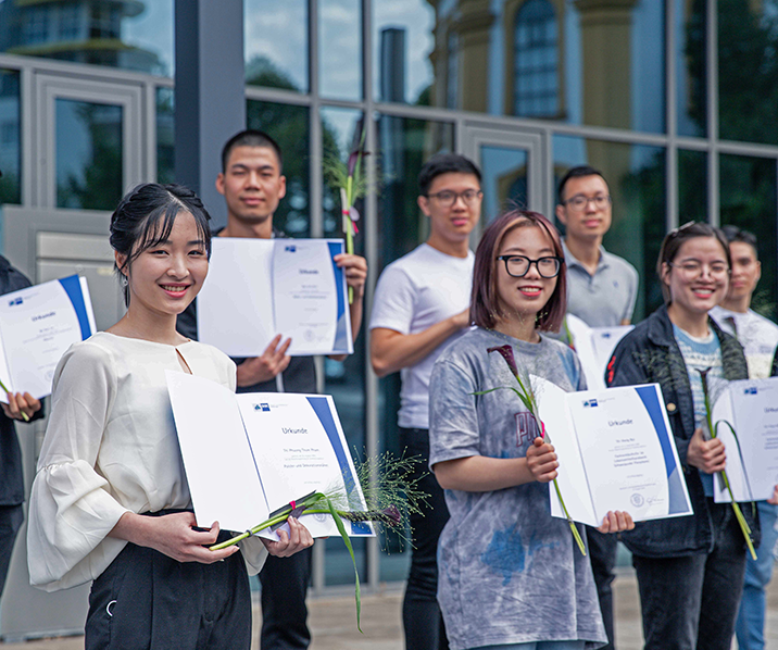 vietnamesische Auszubildende halten ihre Abschlusszeugnisse in den Händen