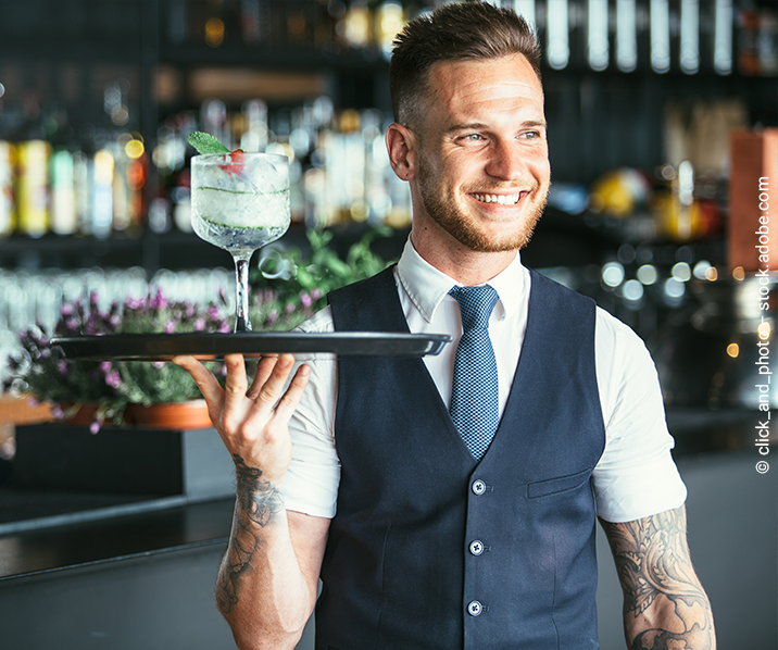 Barkeeper serviert Cocktail auf einem Tablett. 