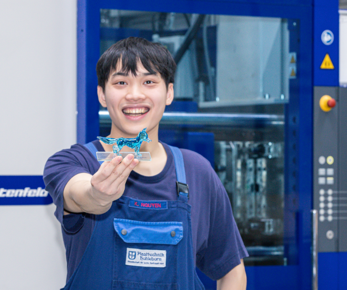 Der gebürtige Vietnamese Khanh Duy Nguyen hält seinen blauen Bildungsfuchs strahlend in den Händen. 