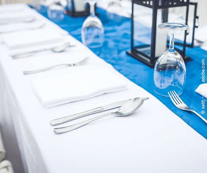 Tisch ist mit Besteck und Gläsern gedeckt. 