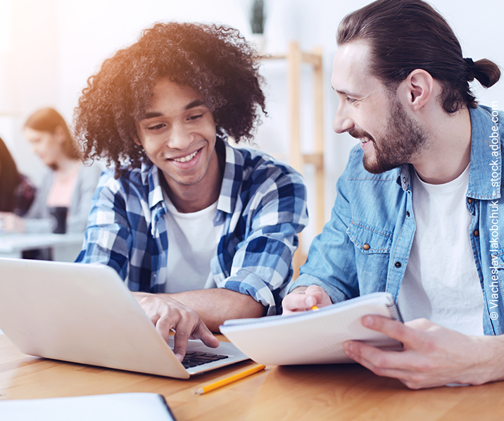 Ein junger Mann bekommt von seinem Lehrer etwas erklärt.