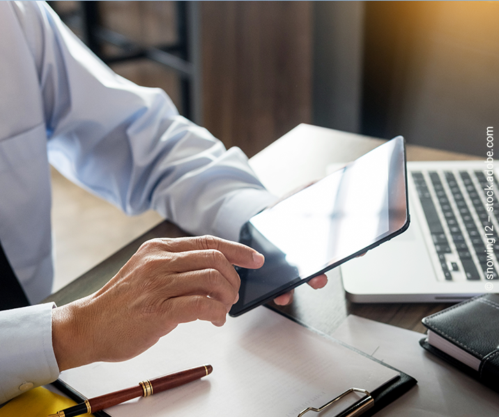 Hand tippt auf Tablet. 